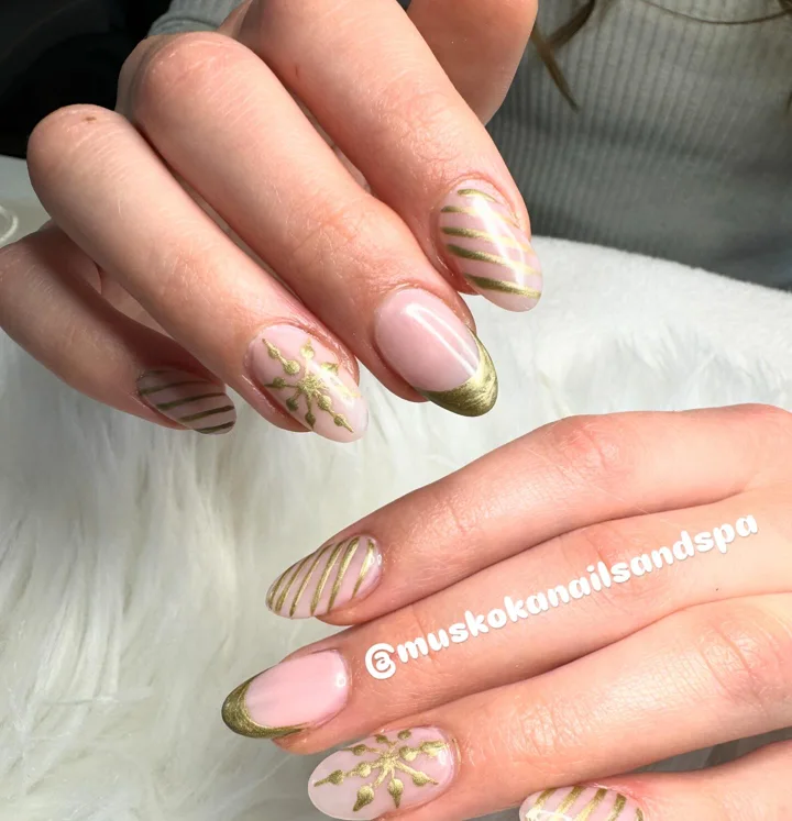 Blush oval nails with gold French tips, stripes and seasonal details by Muskoka Nails & Spa