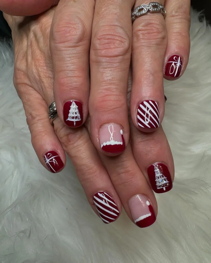 Red short nails with white ribbons and Christmas tree designs by Muskoka Nails & Spa