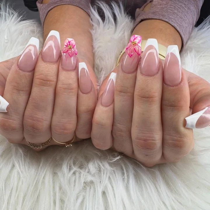Long white French tips with pink three-dimensional flowers by Muskoka Nails & Spa